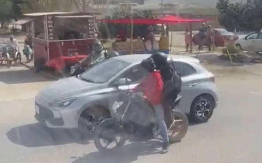 Dos sujetos a bordo de motocicletas asaltan violentamente a una mujer en una calle de Oaxaca, amenazándola con un arma de fuego.