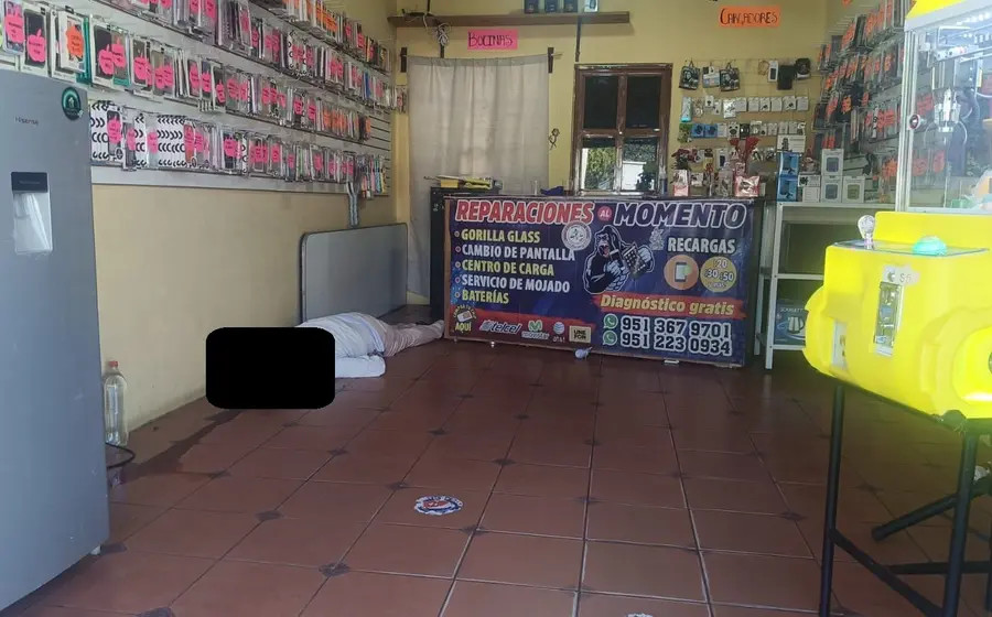 El cuerpo sin vida de 'El Chava Michoacano' dentro de su local de reparación de celulares, luego de ser ejecutado en San Pedro Ixtlahuaca.
