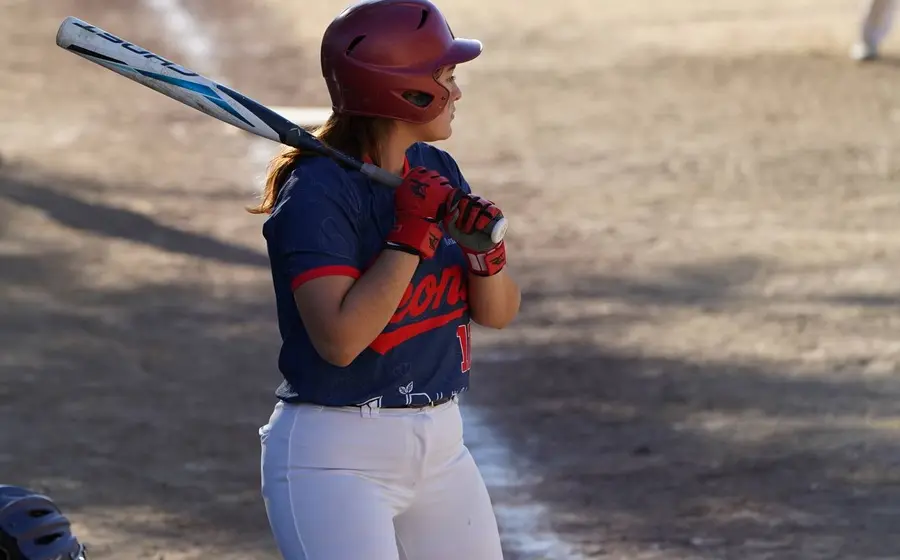 Una jugadora experimentada de la liga de softbol femenil Primera Fuerza se concentra en el diamante durante un intenso duelo por el campeonato.