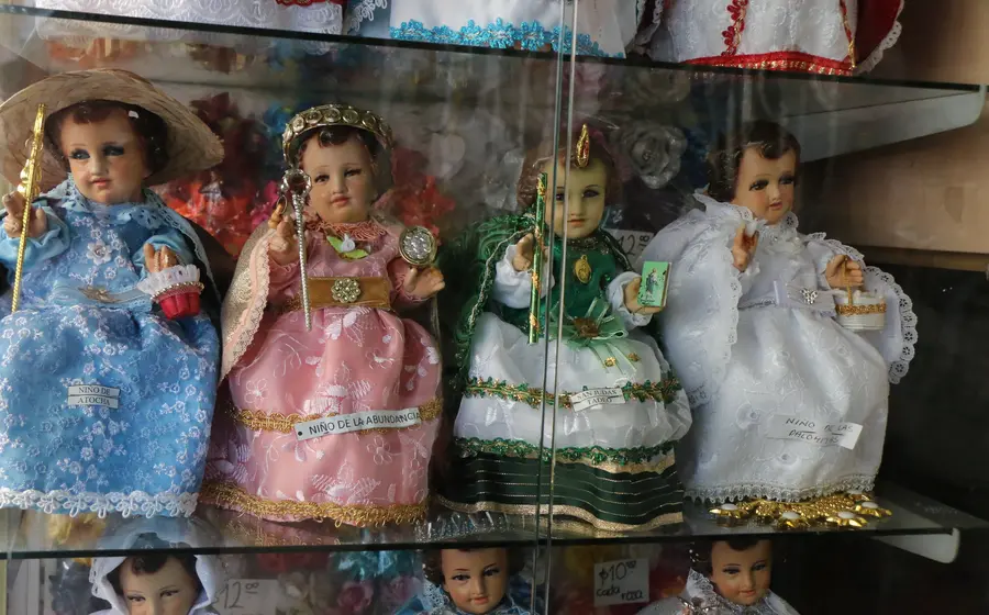 Varias figuras del Niño Dios vestidas con diferentes trajes, representando la tradición mexicana de elegir una madrina para su cuidado anual.