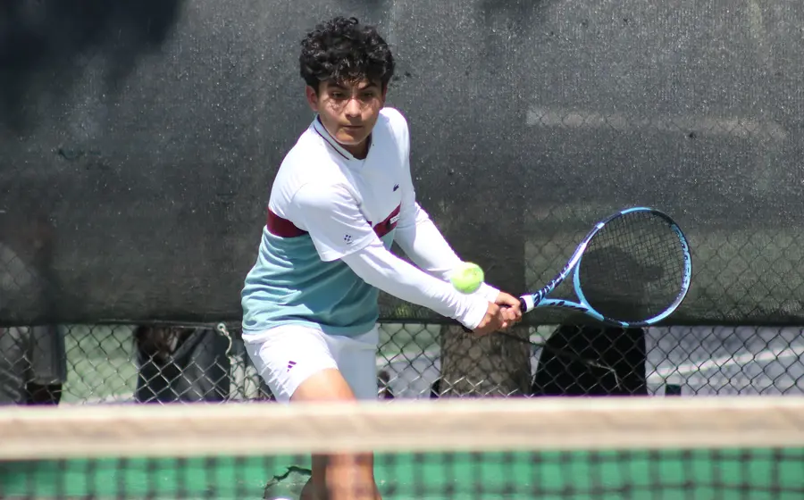 Un tenista en plena acción durante el Torneo Regional de Oaxaca, concentrado mientras se prepara para ejecutar su mejor golpe en la cancha.
