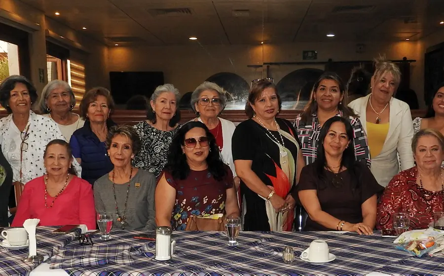 La apreciada Liliana Rivas Torruco, usando un vestido negro con flor, celebra su cumpleaños rodeada de familiares y amigas durante un festejo.