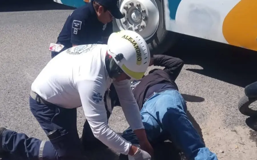 Un policía auxiliar y su hijo de nueve años reciben atención en el lugar del accidente, después de resultar con lesiones al ser arrollados.