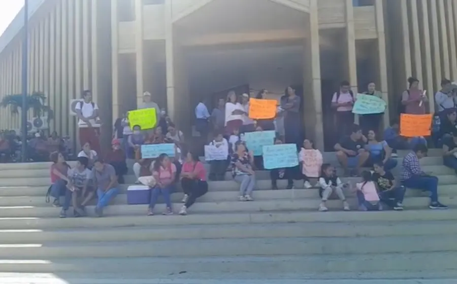 Padres de familia y docentes protestan frente al Palacio Municipal de Salina Cruz para exigir seguridad y luz eléctrica en su escuela.