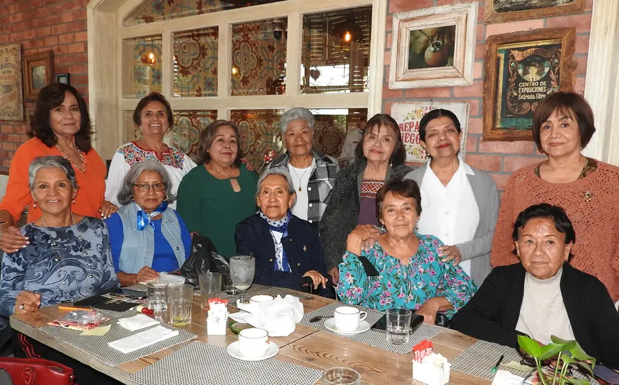 Un grupo de amigas, Idalia, Elena, Sara, Irma, Margarita y más, posan sonrientes durante una reunión social para celebrar momentos especiales juntas.