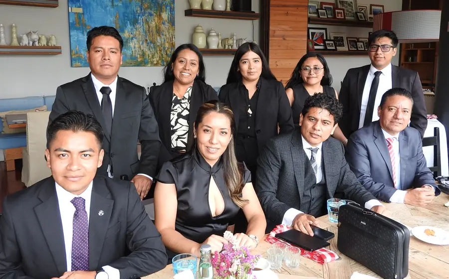 Un grupo de abogados y abogadas penalistas celebran felices el Día del Abogado, posando juntos durante una amena convivencia.