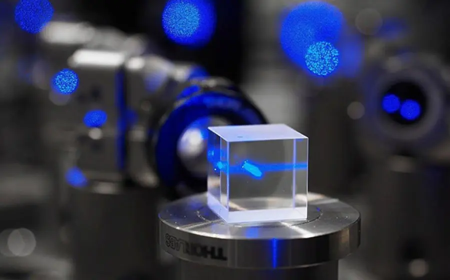 Ilustración conceptual de átomos ultrafríos dentro de un detector cuántico, tecnología del futuro para estudiar materia oscura y ondas gravitacionales con precisión.