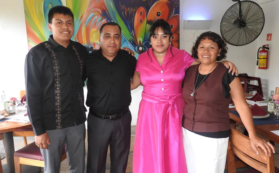 Juliana Haromi González Bernal celebra su graduación en Psicología de la Universidad La Salle, posando felizmente junto a sus padres y su hermano.