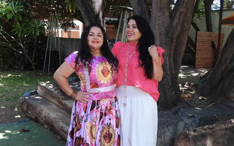 Nayeli Cuevas y Georgina Meneses sonríen para la foto mientras disfrutan de una agradable plática y un café en un evento social.