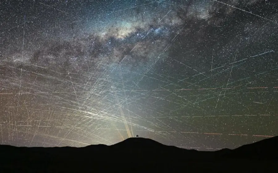 Cielo nocturno estrellado interrumpido por las estelas de luz de satélites comerciales, una amenaza que altera la investigación astronómica de los científicos.