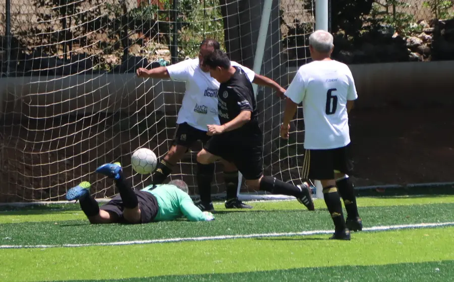Jugadores de los equipos SCK Lomas y Los Dones disputan el balón durante un partido de la jornada siete de la Liga Futbol Premier Dominical.