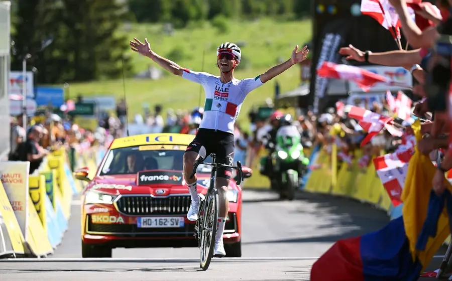 El ciclista mexicano Isaac del Toro celebra su victoria al ganar la etapa final del Tour Auvergne-Rhône-Alpes 2026 en los Alpes.