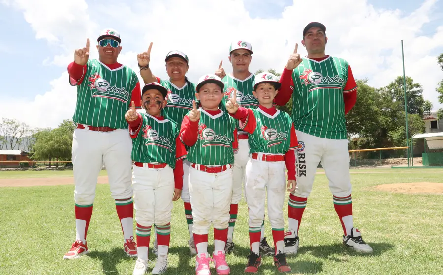Jóvenes beisbolistas de la Liga Petrolera posan sonrientes junto a sus entrenadores tras coronarse campeones en la final del torneo Regional Pre Moyote.