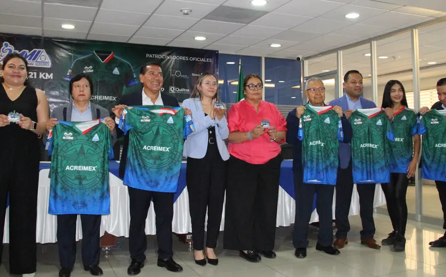 Las playeras y medallas oficiales para la novena edición del Medio Maratón Acreimex 2026 son exhibidas durante el evento de presentación.