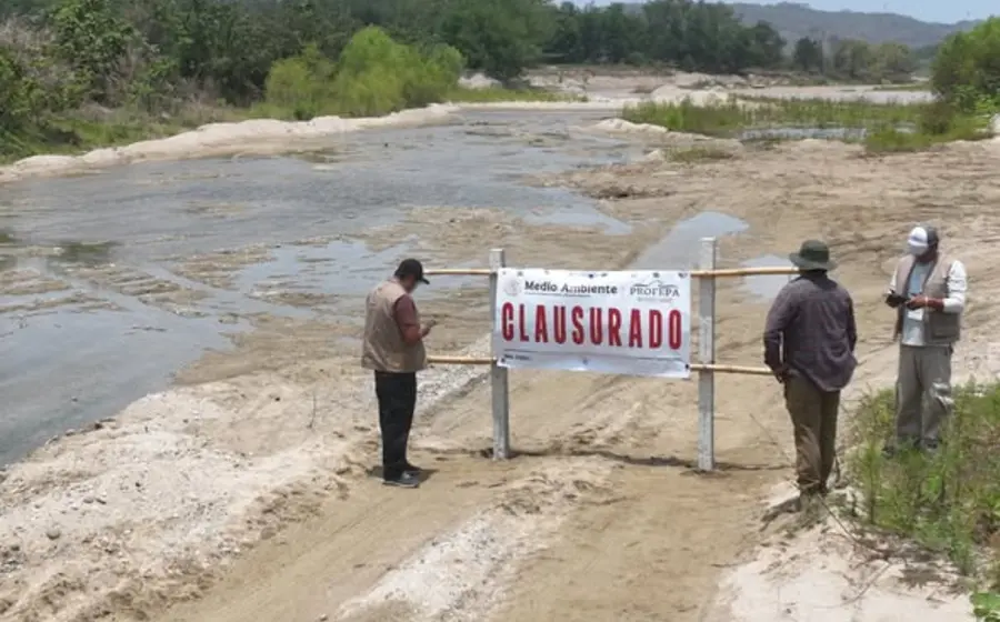 Maquinaria pesada opera sobre el cauce del río Colotepec durante la clausura de un banco ilegal de materiales pétreos por la Profepa.
