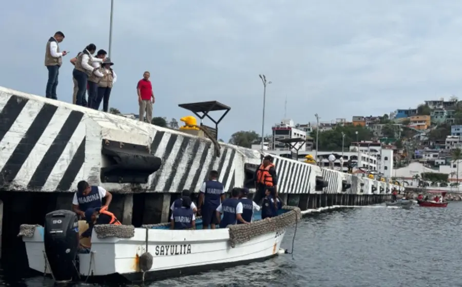 Personal de la Semar realiza labores de limpieza en el muelle turístico de Manzanillo debido a un derrame de hidrocarburo en la zona.