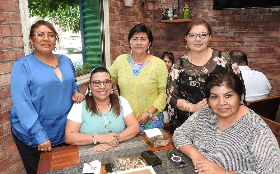 La abogada Araceli Pinelo López celebra su cumpleaños en un desayuno, sonriendo sentada a la izquierda junto a sus colegas y amigas.