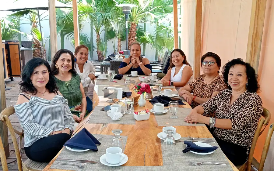 Mónica Yáñez celebra su cumpleaños en un restaurante de Oaxaca, sonriendo al centro y rodeada por su grupo de amigas cercanas.