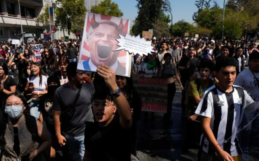 Jóvenes estudiantes protestan en las calles de Chile con pancartas en contra de los recortes a la educación gratuita propuestos por el gobierno.