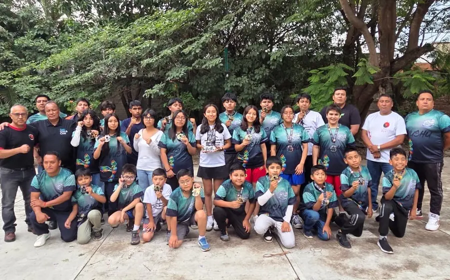 Los niños y jóvenes artemarcialistas con sus medallas, a lado de entrenadores