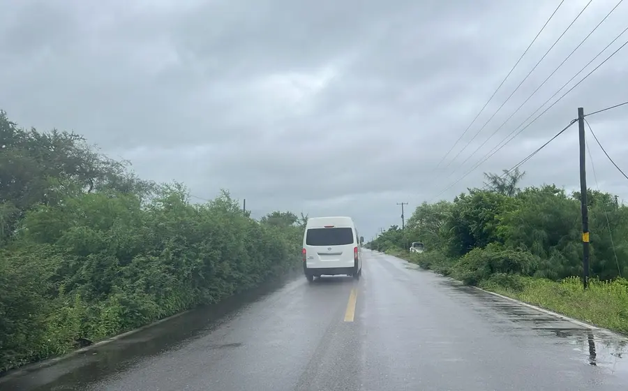 Un vehículo circula con dificultad bajo una lluvia intensa, ilustrando la recomendación de las autoridades de reducir la velocidad en el Istmo de Tehuantepec.
