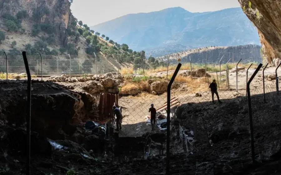 Una cueva prehistórica que representa los refugios estratégicos y puntos de disputa, ilustrando el concepto del primer lenguaje territorial para la humanidad.