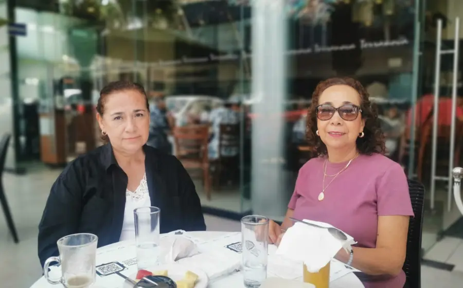 Las hermanas Esperanza y Norma García Ramírez posan para la foto mientras comparten un rico desayuno y una amena charla.