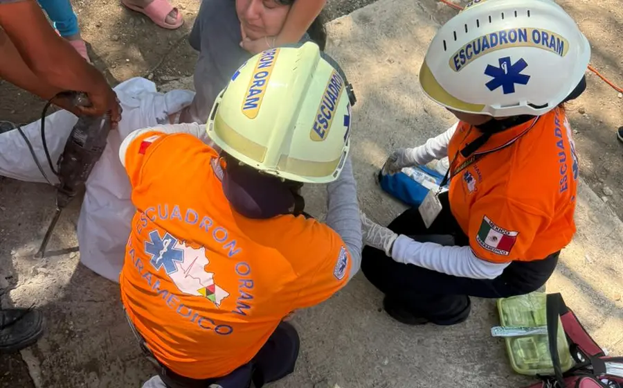 Una joven de 15 años es atendida por paramédicos tras ser rescatada de una letrina donde cayó y se lesionó con una varilla.