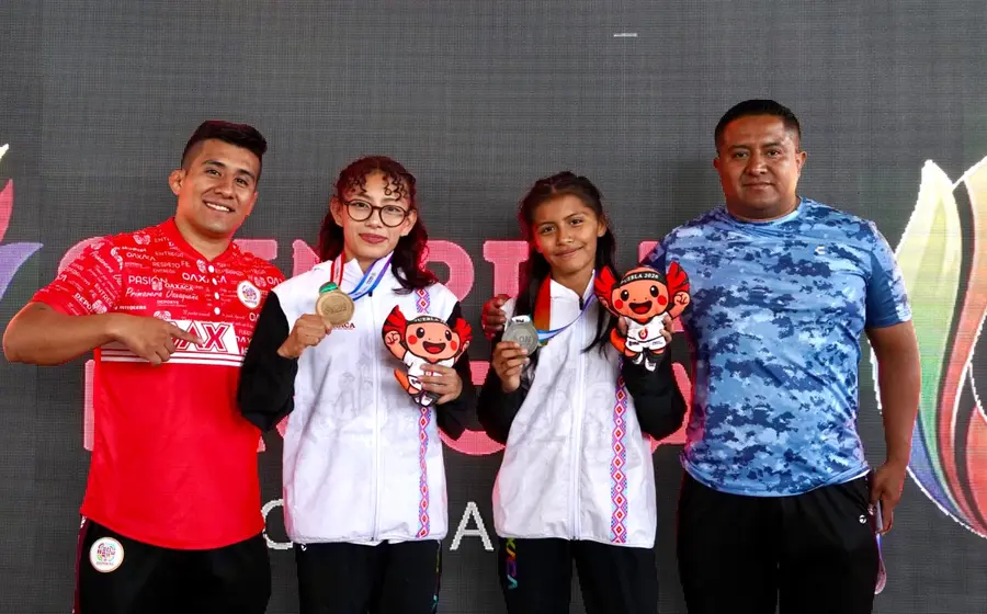 Una atleta oaxaqueña de lucha femenil celebra su victoria tras ganar la medalla de oro en la competencia final del torneo.