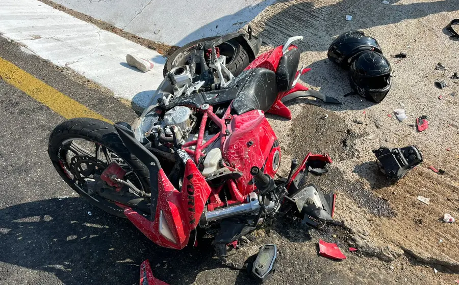 Un motociclista recibe atención médica en el lugar del accidente tras chocar contra un camión de volteo en la localidad de Pochutla.