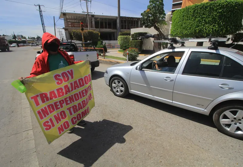 Persona con lona pidiendo trabajo en la calle
