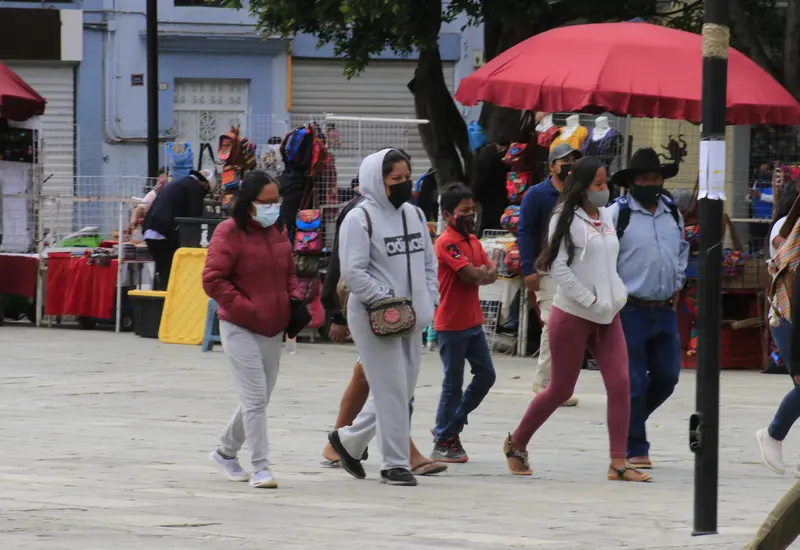Gente con cubrebocas caminando.