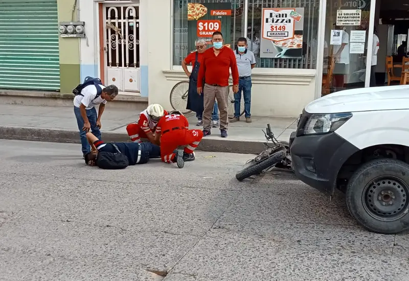 La motocicleta quedó tirada enfrente de la camioneta.