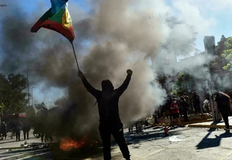 Persona sosteniendo bandera durante protestas en Chile