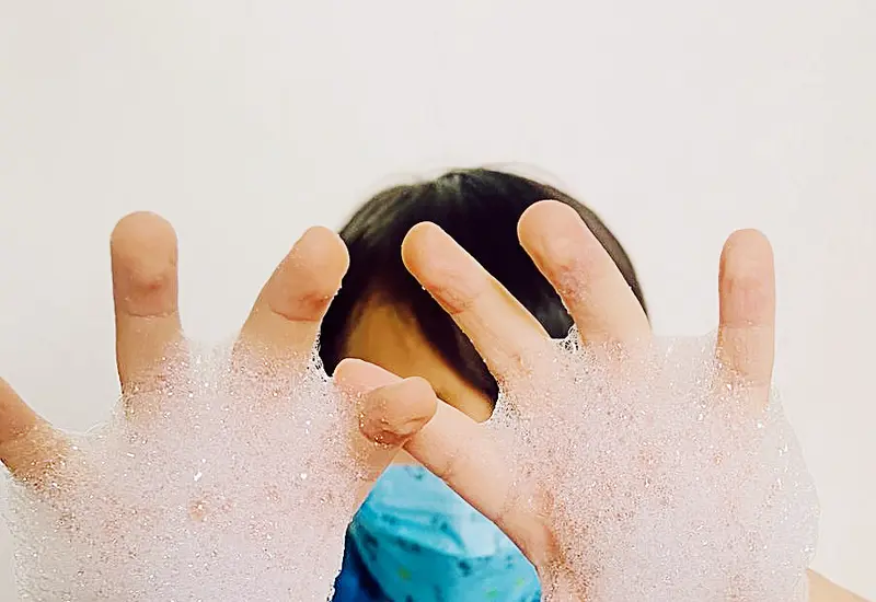 Niño con las manos lavadas con agua y jabón