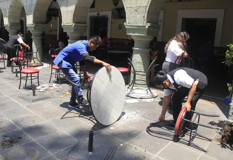 Jóvenes recogiendo mesa y sillas