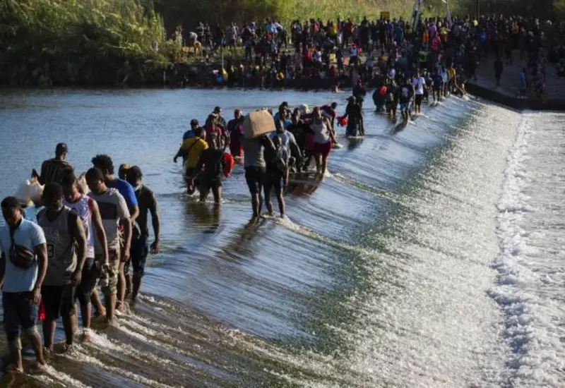 Migrantes cruzaban desde Ciudad Acuña en México hacia Del Río, Texas, a través del puente y el río.