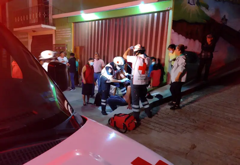 Cruz roja mexicana atendiendo a joven golpeado