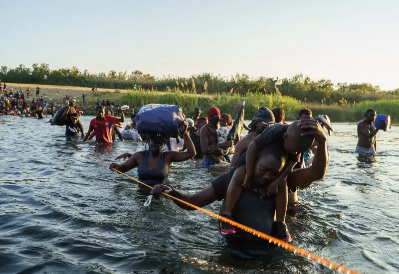 Migrantes cruzando el río