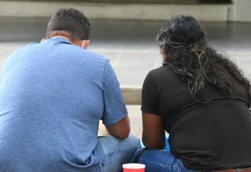 Personas con obesidad sentadas en la calle.