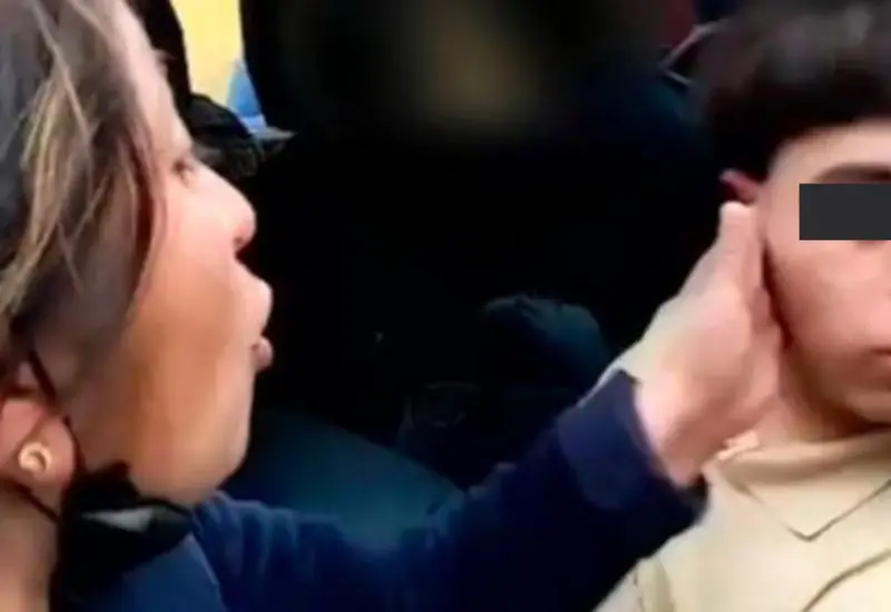 La mujer da cachetada a su hijo quien no dice alguna palabra.