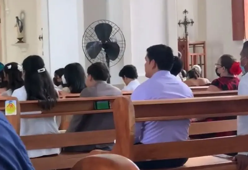 En las imágenes se ve a un hombre en misa viendo en su celular uno de los partidos del mundial.