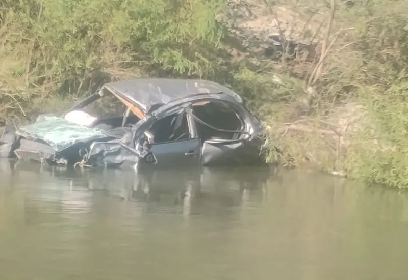 Una camioneta volcada y parcialmente sumergida en una poza de agua tras un accidente fatal que dejó un muerto y tres lesionados.