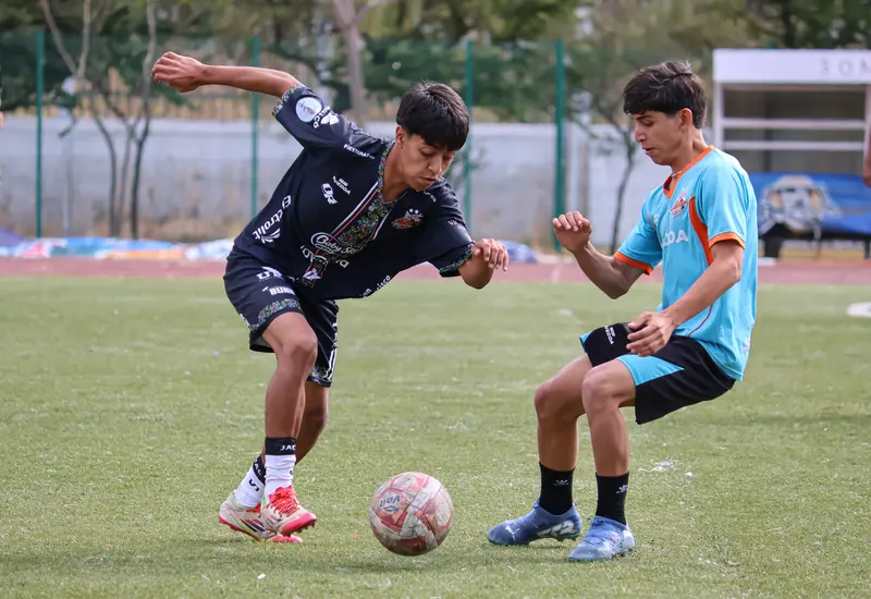 Jóvenes futbolistas compiten en intensos duelos durante el torneo draft del equipo Alebrijes, buscando una oportunidad para mostrar su talento.