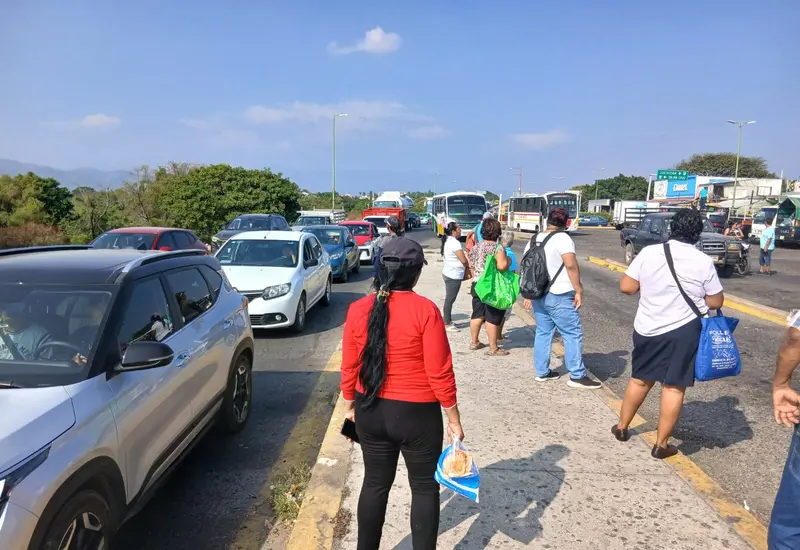 Larga fila de automóviles congestionando una calle principal, reflejando la creciente afluencia vehicular en la ciudad de Tehuantepec, Oaxaca.