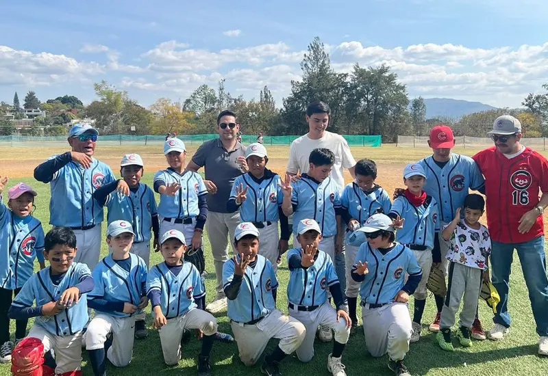 Los jugadores del equipo Cachorros Lma levantan el trofeo de campeones, celebrando con entusiasmo la obtención de otro título para su club.