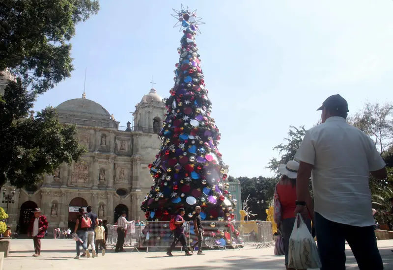 Adornos y esferas navideñas coloridas en exhibición en un mercado de Oaxaca, representando el alto costo de la decoración para la temporada festiva.