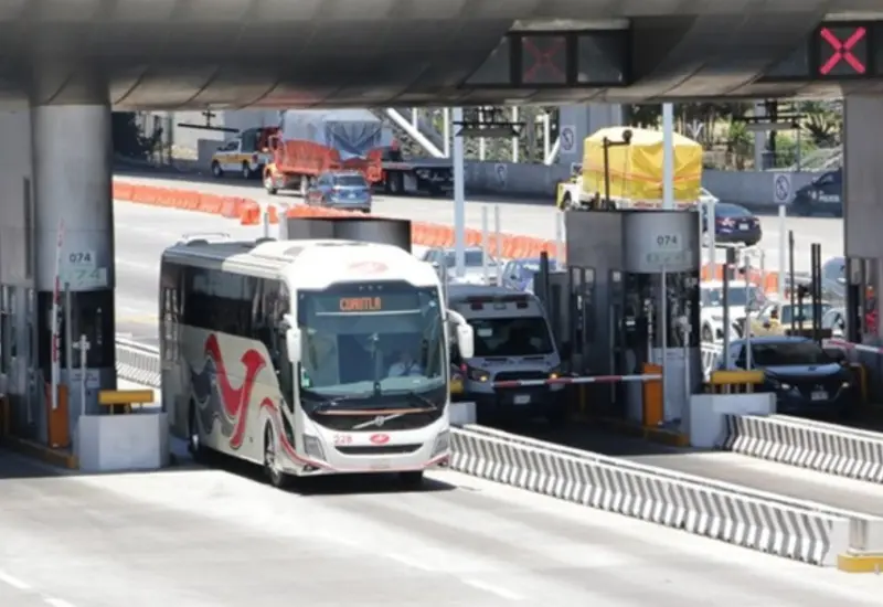 Un autobús de pasajeros en una terminal, ilustrando los descuentos vacacionales para estudiantes y docentes en el transporte federal y de tren.