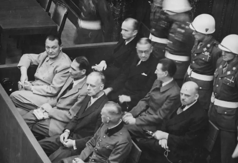 Fotografía histórica en blanco y negro de los dirigentes nazis sentados en el banquillo durante las audiencias de los Juicios de Núremberg.