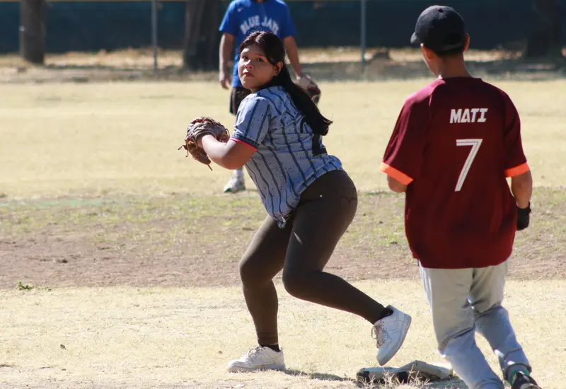 Una jugadora de béisbol del equipo Chivines se mantiene atenta en la segunda base durante un partido celebrado en el diamante.